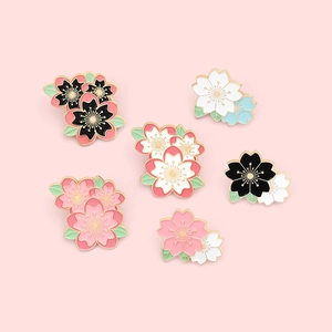 Lot de six épingles en émail cerisier japonais avec bordure dorée sur fond rose doux