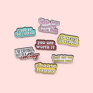 Lot de 7 épingles en émail colorées avec slogans anglais sur fond rose clair