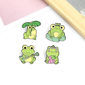 Lot de quatre pin's grenouille en émail vert avec motifs fraise et guitare mignons
