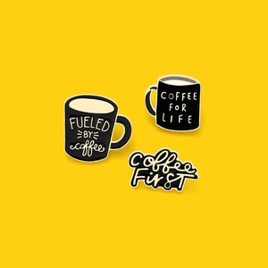 Three-piece set of black enamel coffee pins with gold-plated edges on yellow background