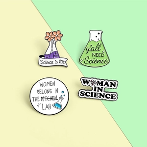Set of four cartoon science enamel pins with lab beakers and empowering women slogans