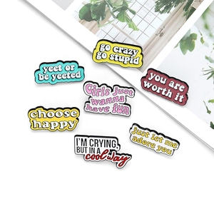 Détail de sept épingles en émail colorées avec des citations motivantes variées