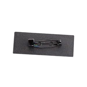 Back view of rectangular matte black metal brooch with a secure metal safety pin closure