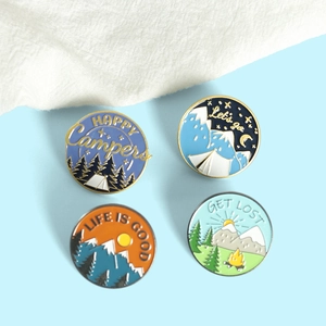 Set of four colorful outdoor camping enamel pins featuring mountains and forest designs