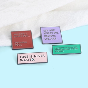 Set of four colorful enamel lapel pins with motivational English quotes on metal
