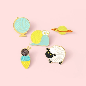 Set of five cute animal enamel pins with creative yarn ball designs on pink background