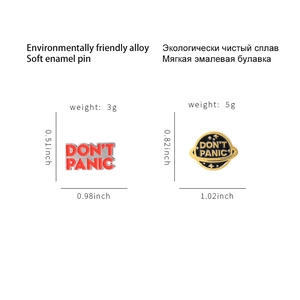 Red rectangle and black planet enamel pins featuring DON'T PANIC text in alloy