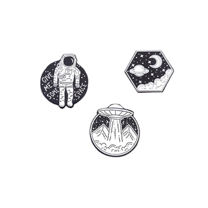 Lot de trois pin's en émail noir et blanc avec motifs astronaute et OVNI en alliage