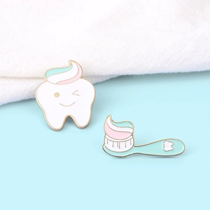 Cartoon enamel pin set featuring cute tooth and toothbrush figures on blue background