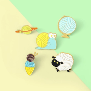 Set of 5 colorful enamel pins featuring cartoon sheep, snail, and knitting textures