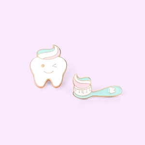 Cartoon tooth and toothbrush enamel pins set on a minimalist light purple background
