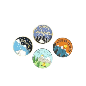 Set of four round enamel pins with mountain hiking and camping nature landscape designs