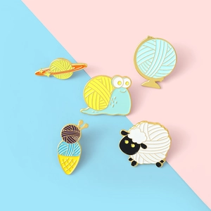 Five-piece cartoon enamel pins set featuring knitting motifs on sheep, snail, and earth