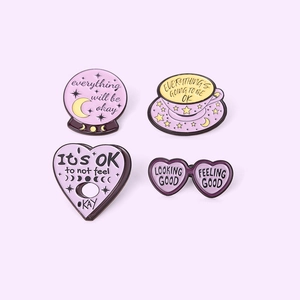 Set of four purple enamel pins with motivational quotes and celestial star patterns