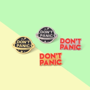 Detailed close-up of Don't Panic enamel pins showing planet designs and vibrant metal plating