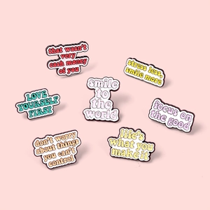 Set of 7 colorful enamel pins with motivational English quotes on pink background