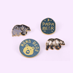 Detail of Papa Bear and Mama Bear enamel pins with nature scenery and mountain patterns