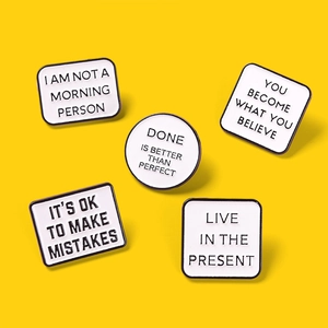 Minimalistische zwart-witte emaille pinnen set met motiverende tekst op gele achtergrond