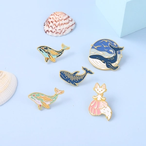 Ocean theme enamel pin set featuring blue whales and a cute cat on a blue background