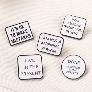 Set van 5 minimalistische emaille pinnen met zwarte belettering op stof