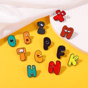 Close-up of Alphabet Lore colorful enamel lapel pins on a modern geometric display