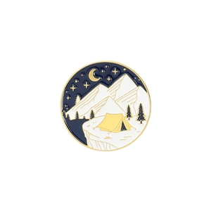 Detailed close-up of a circular enamel camping badge with moon, mountains and starry sky