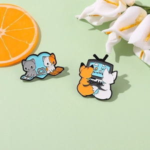 Cute cartoon fox and cat reading books enamel pins on a fresh green background