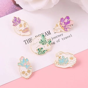 Set of five punk crystal skull enamel brooches in gold finish with colorful quartz details