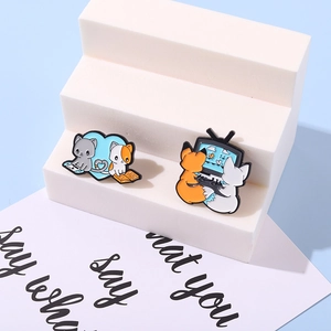 Close-up of cute cartoon fox and cat enamel pins on a white decorative display stand