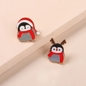 Christmas penguin alloy brooch set with red hats and reindeer antlers on a beige stand