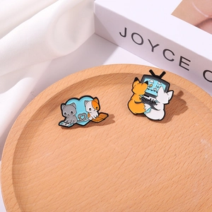 Detailed close-up of cute cartoon enamel badges featuring foxes and cats on a wooden tray