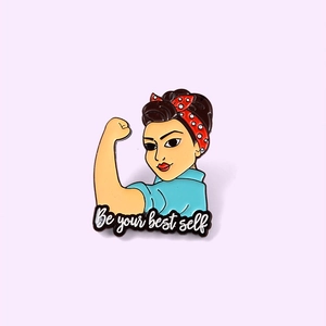 Détail de l'épinglette en émail 'Be your best self' avec le motif de Rosie la riveteuse