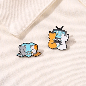 Cute enamel fox and cat video game brooches for couples on a beige corduroy texture