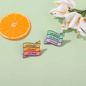 Broches en émail arc-en-ciel avec citations de motivation sur un fond vert de style frais