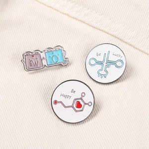 Macro view of Be Happy and Be Lucky enamel pins on denim, showing smooth metal textures