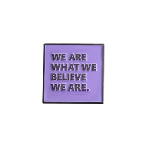Close-up of square purple enamel pin with English inspirational quote and black metal border