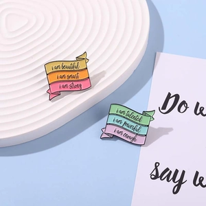 Macaron pastel enamel pins with inspirational quotes on a white decorative plate