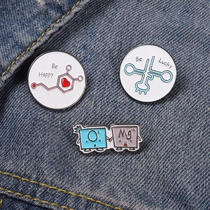 Close-up of O and Mg element symbols and chemical structure enamel pins on denim jacket