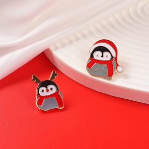 Set mit süßen Weihnachts-Pinguin-Broschen mit festlichen Hüten und Schals auf Rot