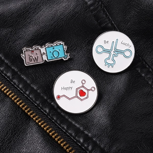 Detail of Be Lucky and Be Happy enamel pins set on a black leather jacket texture