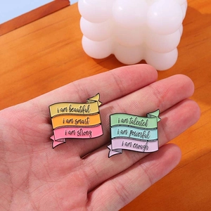 Lot de deux broches en émail coloré avec citations inspirantes sur fond de bois