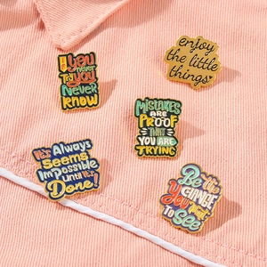 Ensemble de cinq épingles en émail motivantes avec slogans anglais sur tissu rose