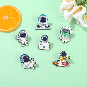 Close-up of enamel astronaut lapel pins featuring space themes and music motifs