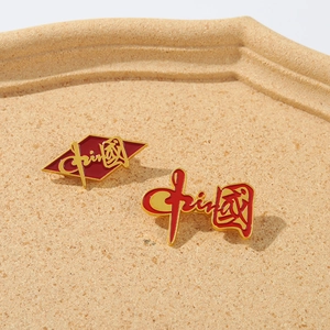 Macro shot of red and gold enamel Chinese pins featuring China artistic calligraphy