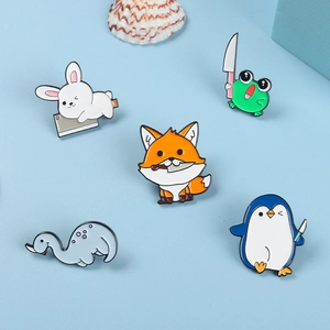 Détail de cinq pin's émaillés d'animaux mignons avec un lapin, un pingouin et une grenouille