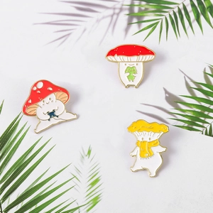 Three cute mushroom enamel pins with personified expressions on a white background