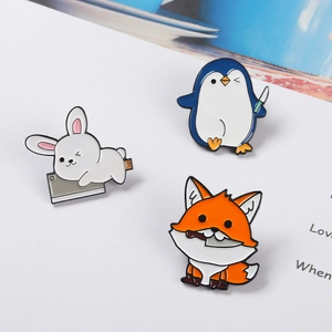 Détails de broches en émail lapin, pingouin et renard mignons sur papier blanc