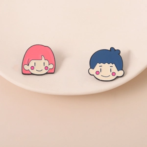 Gros plan de broches émaillées de personnages mignons sur une assiette blanche