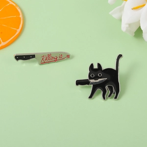 Dettaglio del set di spille smaltate gatto nero con coltello e scritta Killing It