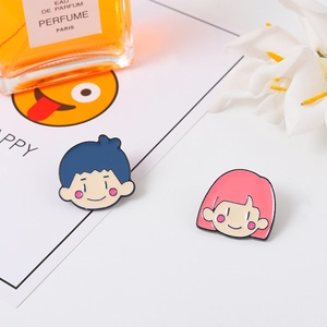 Détail de pins en émail mignons garçon et fille sur un bureau avec accessoires clairs